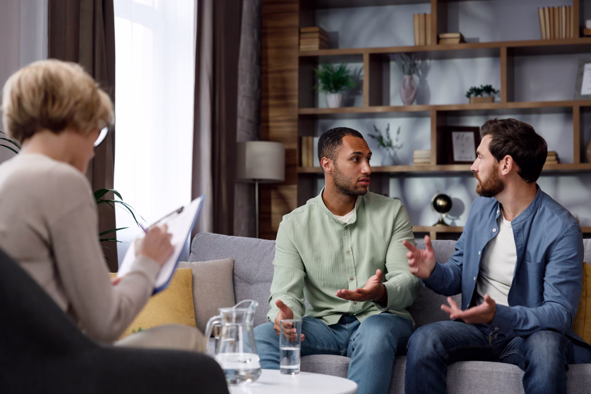 An LGBTQ couple engaging in therapy in a supportive environment.