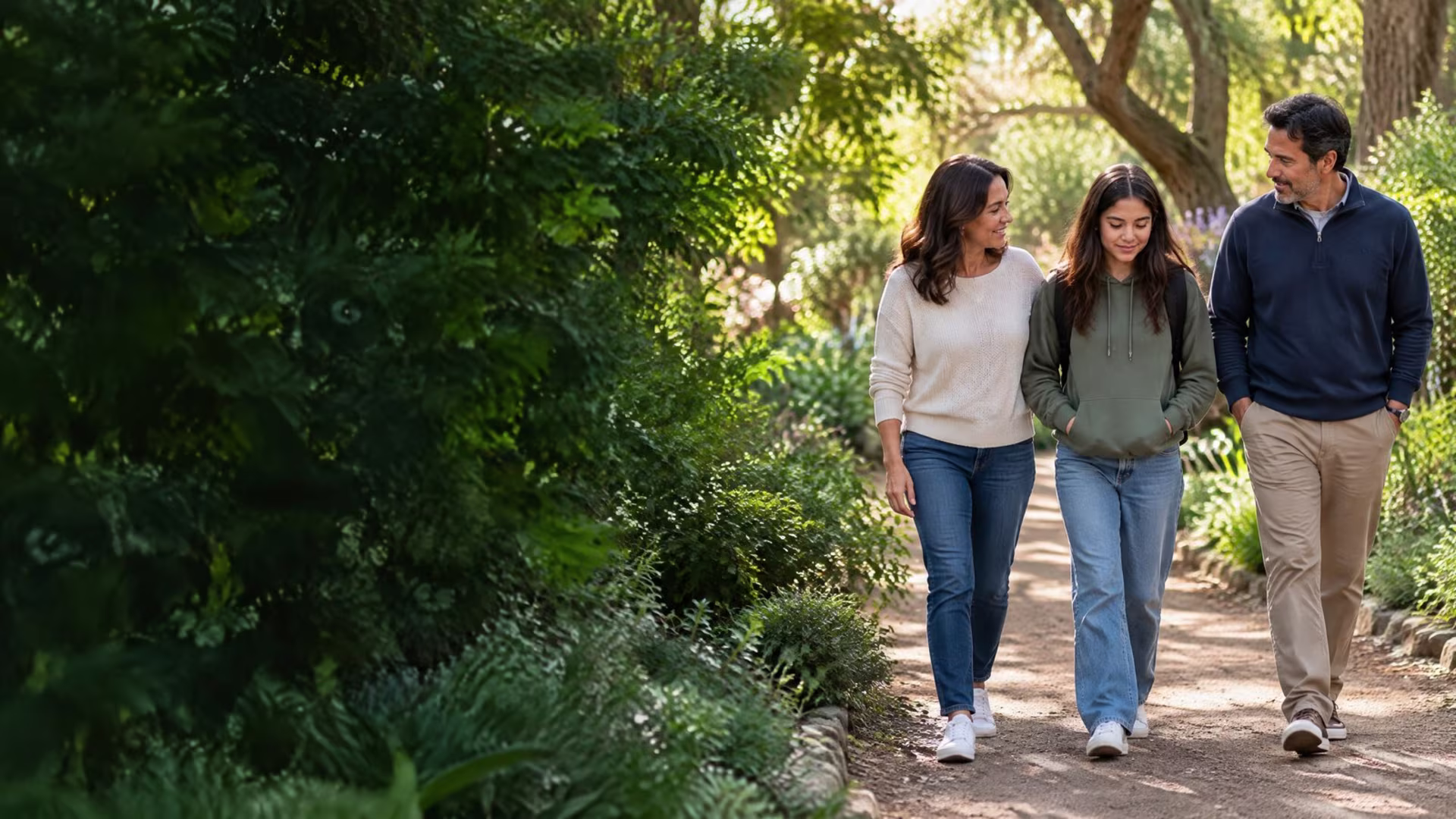 Family walking together along a tree-lined California garden path, family therapy in San Jose near me
