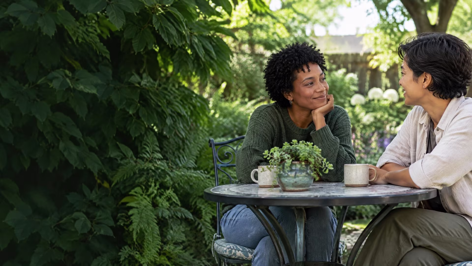 Two adults sharing a relaxed moment at a quiet garden table, autism therapy in San Jose near me