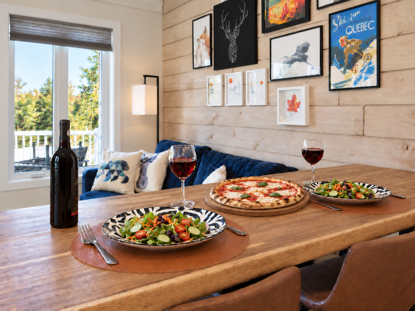 Table pour deux avec pizza, salades et vin rouge au Chalet Aventure Orford