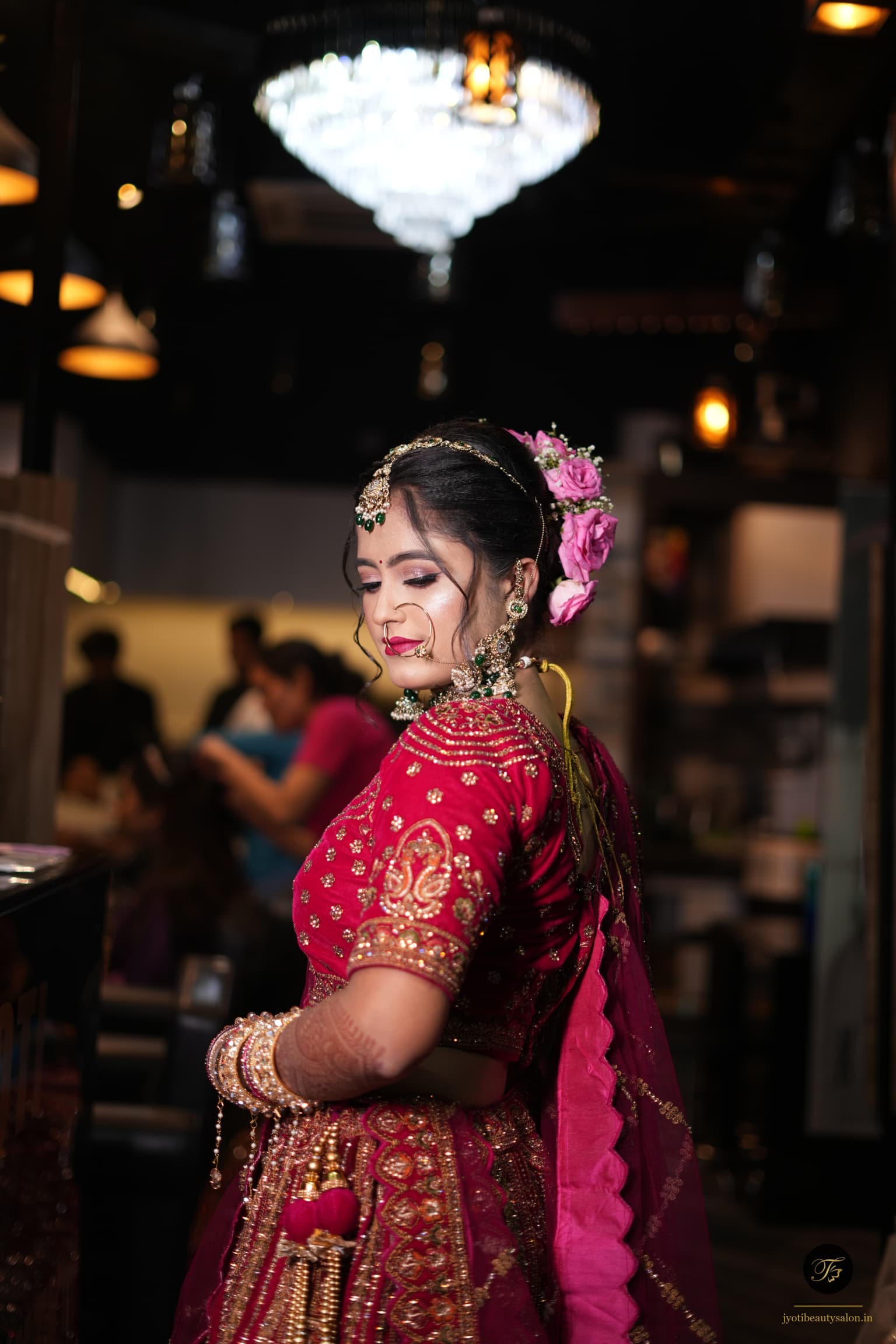 Side profile of a bride in magenta lehenga with heavy gold jewelry by Jyoti Beauty Salon Chapra