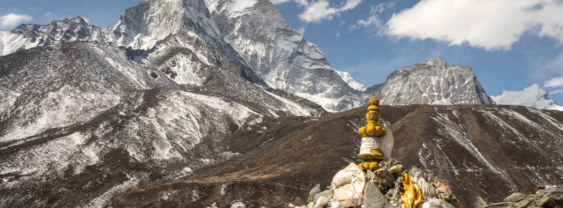 Snow-covered Himalayan peak rising behind a golden Buddha statue