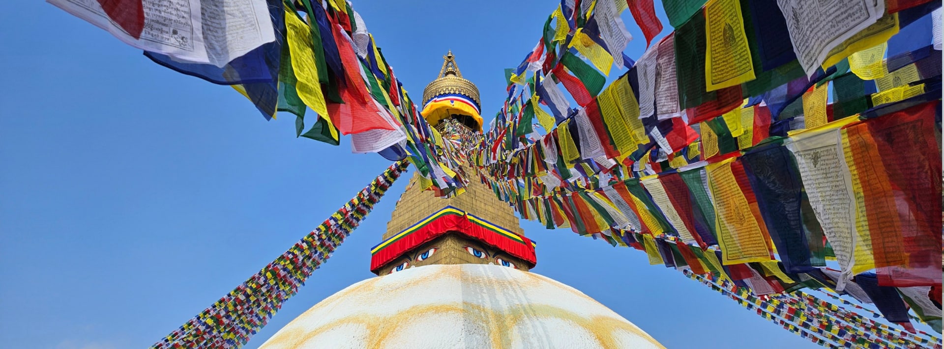 Boudhanath Stupa wrapped in rows of colourful prayer flags