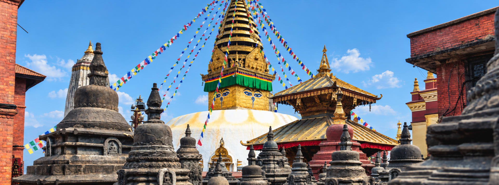 Golden temple spire and stone stupas in a Kathmandu courtyard