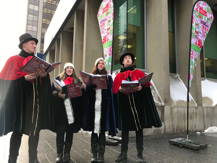 A group of people caroling with Get Cyber Safe branded books