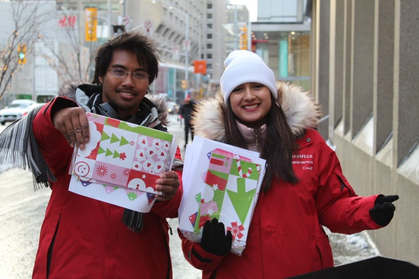 2 people holding Get Cyber Safe branded Christmas gift tag stickers