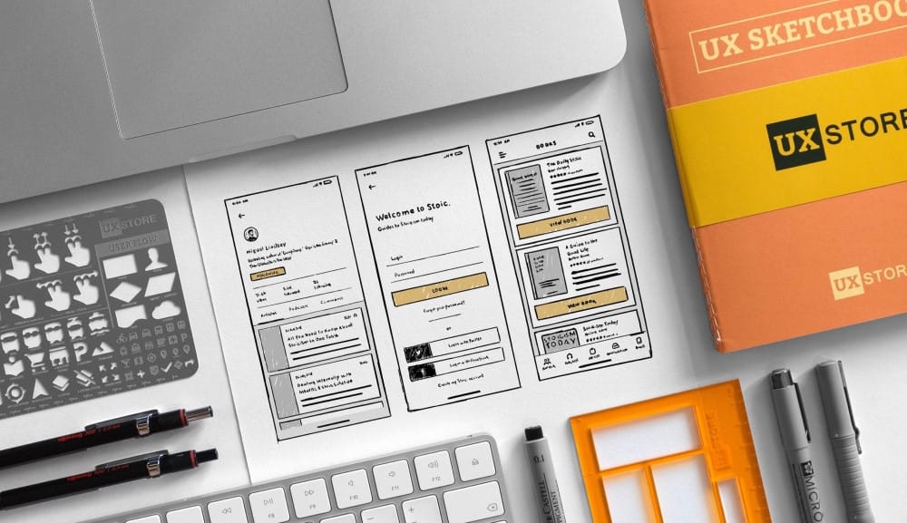 Starting the wireframing process with sketches Laptop, notepad and some UX wireframes