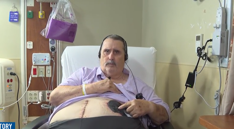傑瑞・岡姆牧師在醫院受訪時揭開手術後的傷疤。(WKYT影片截圖)