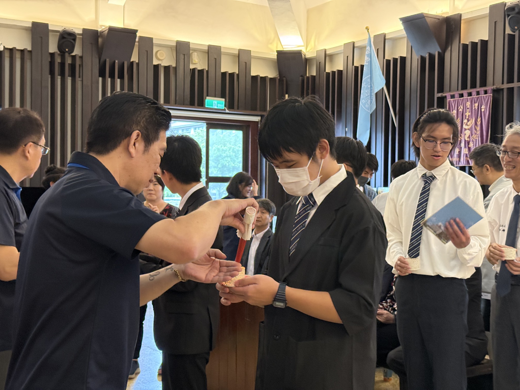 校友總會陳建宏副理事長與陳詩銘秘書長點燃成年同學手中的蠟燭,延續聖約翰傳承「光與真理」的傳統,象徵聖約翰3F精神代代相傳繼續在這一棒一棒的傳承中延續。(圖/聖約翰科技大學提供)