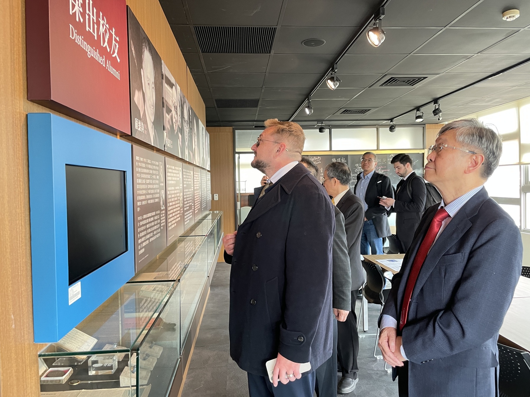 Datavault AI主席暨執行長Nathaniel Bradley及全國商總人資委員會等貴賓仔細瀏覽上海聖約翰大學傑出校友資料，感受「東方哈佛」上海聖約翰大學百年知行合一的教育傳統。(聖約翰科技大學提供)