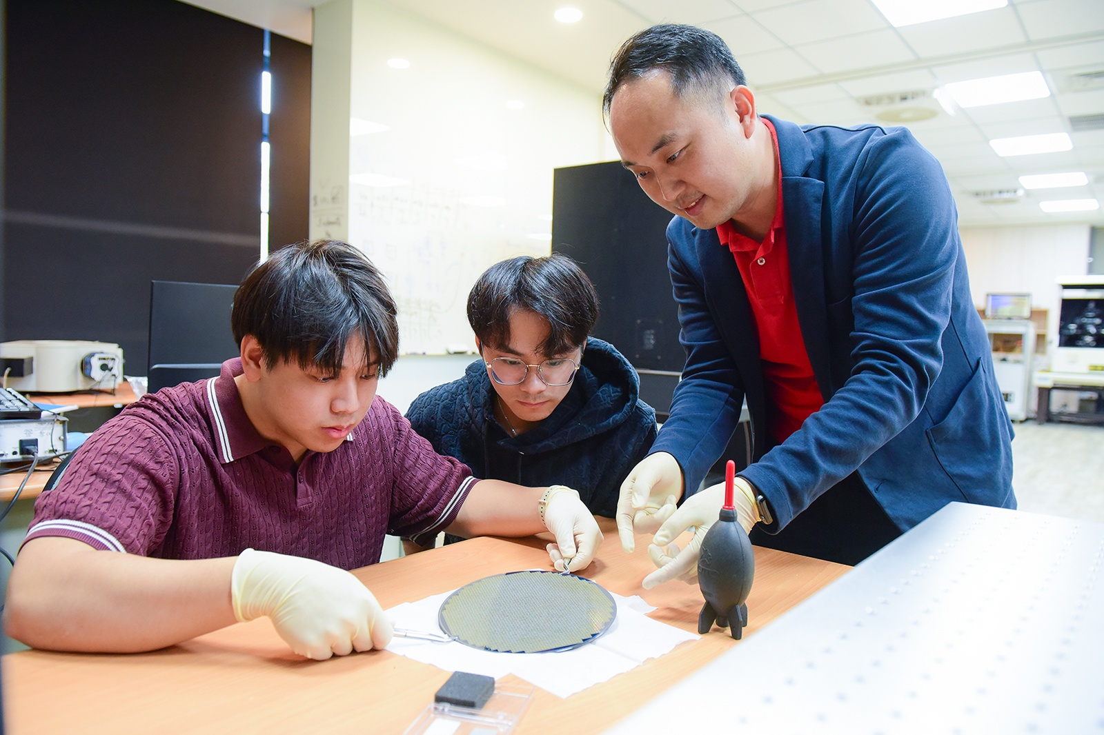 中原大學郭泰辰（右）指導學生確認晶圓量測位置與量測條件設定，確保實驗數據準確性。(圖/中原大學提供)