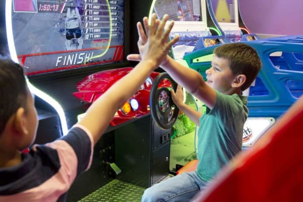 two kids high-fiving while playing games.