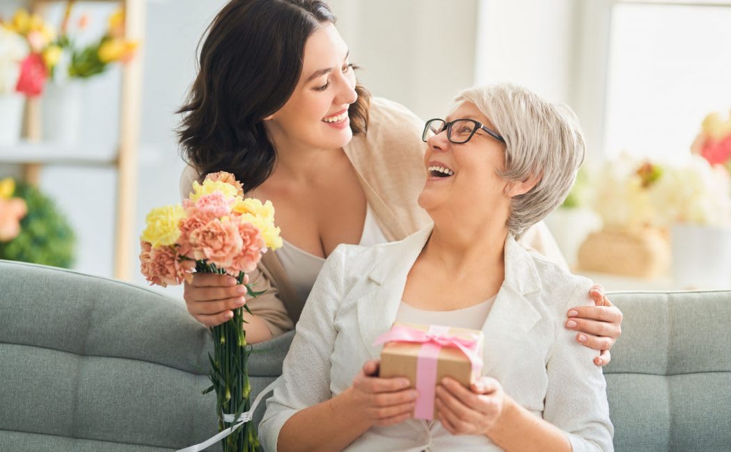A daughter giving her mother flowers and a gift