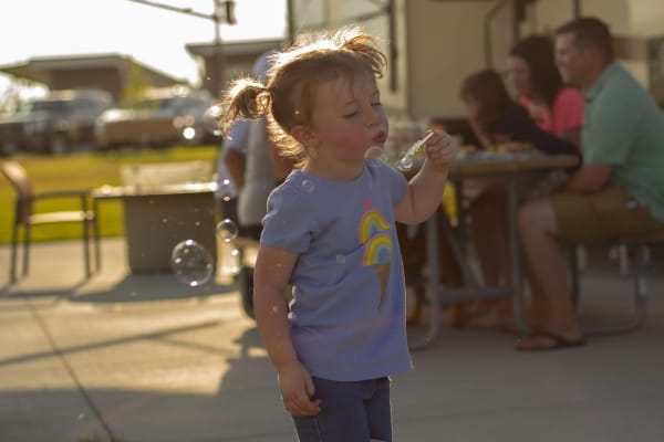 A happy child blowing bubbles.