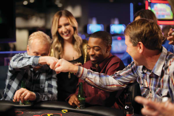 Two players fist-bumping at a gaming table.