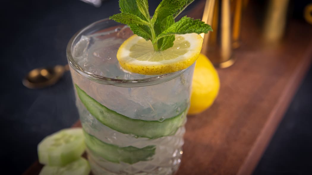 a refreshing cocktail with lemon, cucumber and a sprig of mint