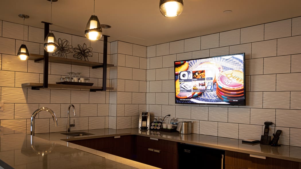 the kitchen area with nice tile and a tv mounted on the wall