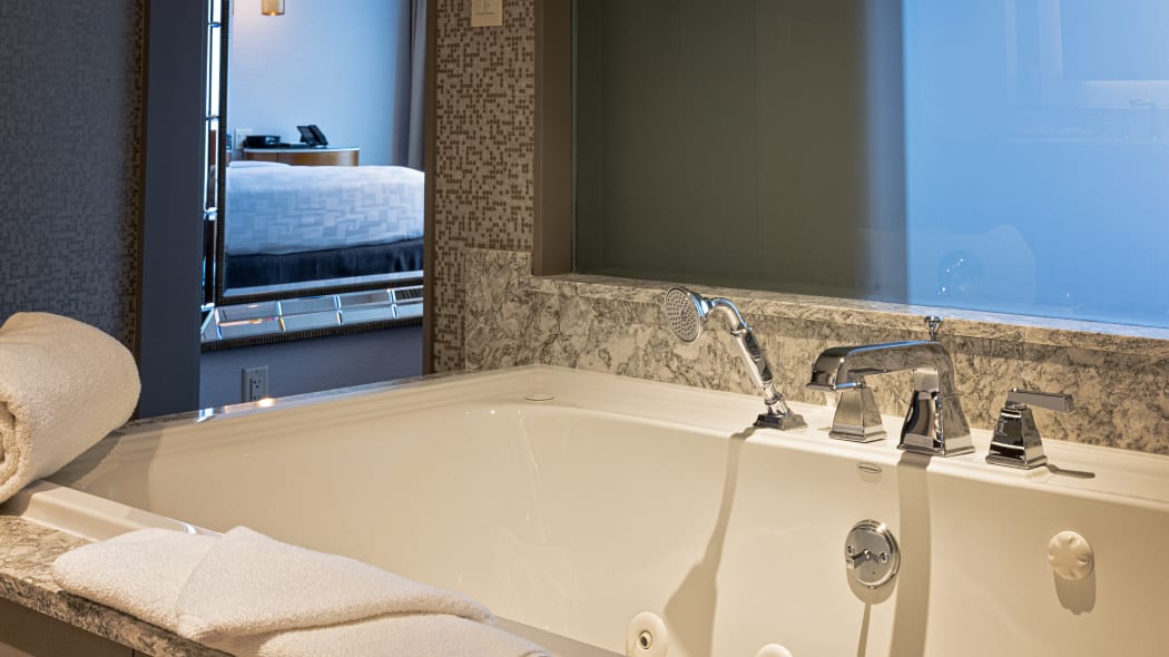 a closeup of the jetted tub with the bedroom in the background