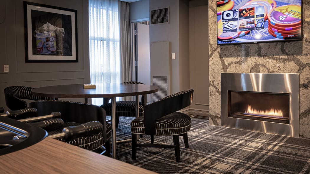 a view of the suite showing a table, fireplace and another wall-mounted tv