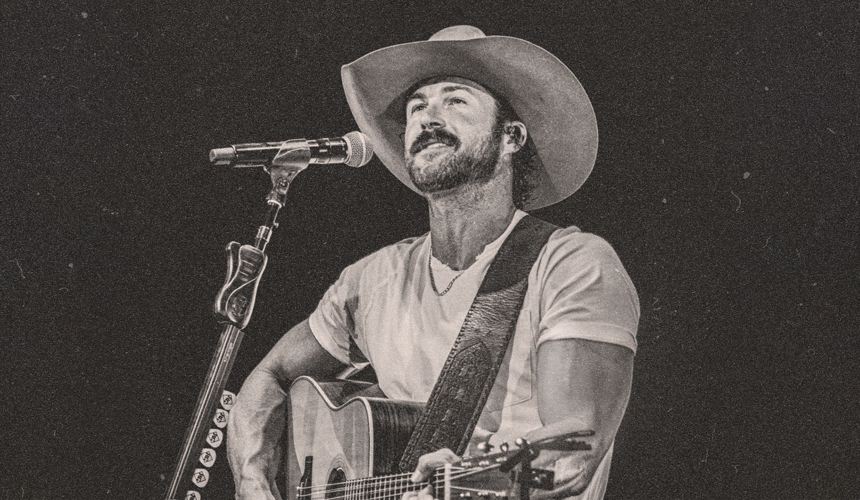 Riley Green holding a guitar on stage