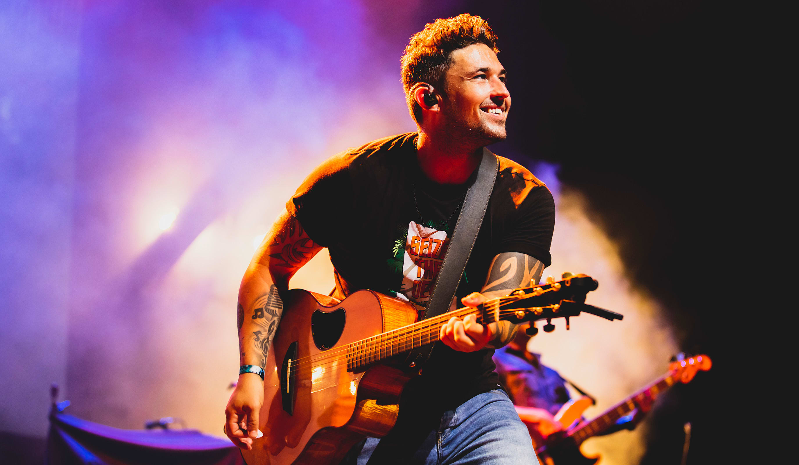 Michael Ray holding a guitar on stage