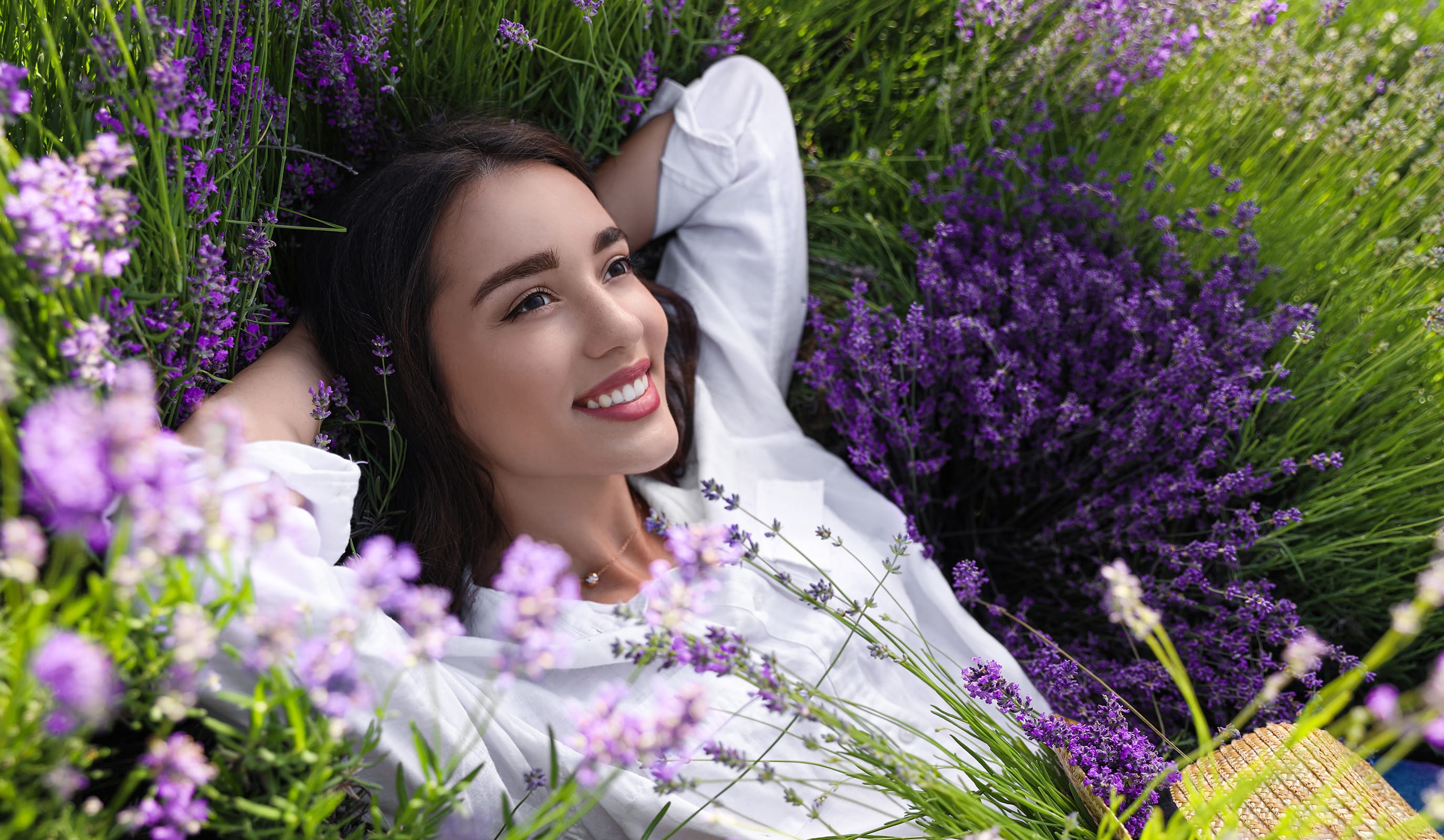 a smiling woman laying in lavender