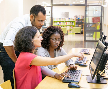 Trainer helping students with computer tasks