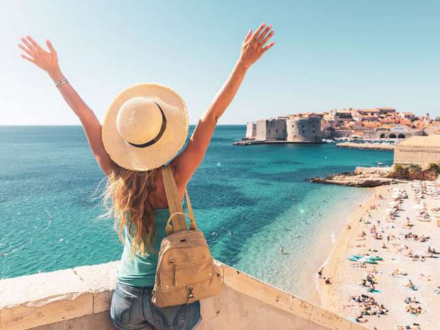 Happy woman tourist enjoying view of the old town of dubrovnik in croatia