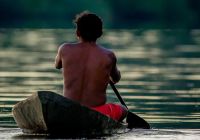 Jovem indígena navegando pelo Rio Amazonas