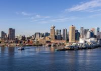 Skyline do centro de Vancouver, BC, Canadá com beira-mar, céu claro e água pacífica.