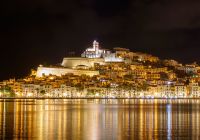 Skyline of ibiza dalt vila downtown at night with light reflections in the water
