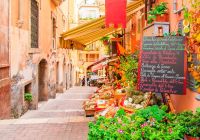 Entrance to local shop in taormina sicily writing on the black table lists itmes on promotion