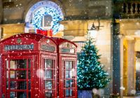 Cabines telefonicas vermelhas classicas com neve caindo em frente ao natal
