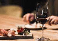 People drinking wine and eating cold cut meat in a wine cellar
