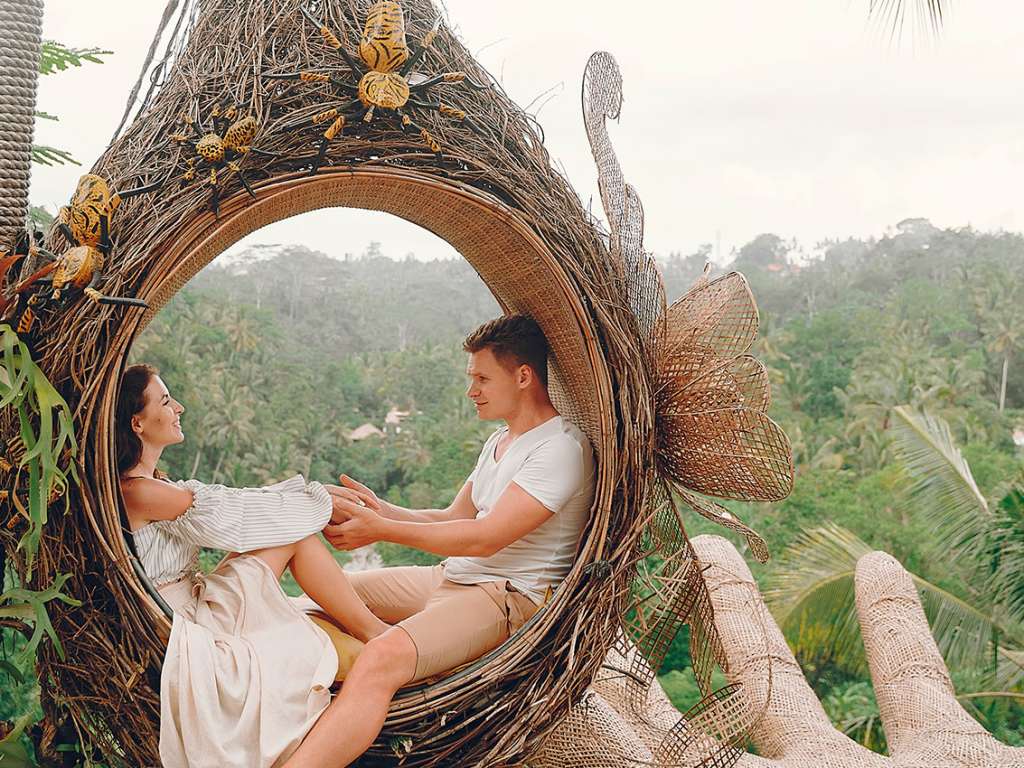 Casal sentado em um grande ninho em Bali