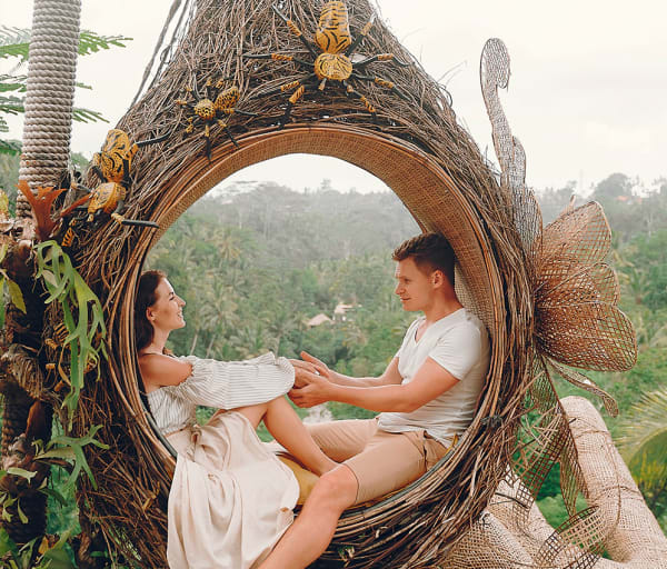 Casal sentado em um grande ninho em Bali