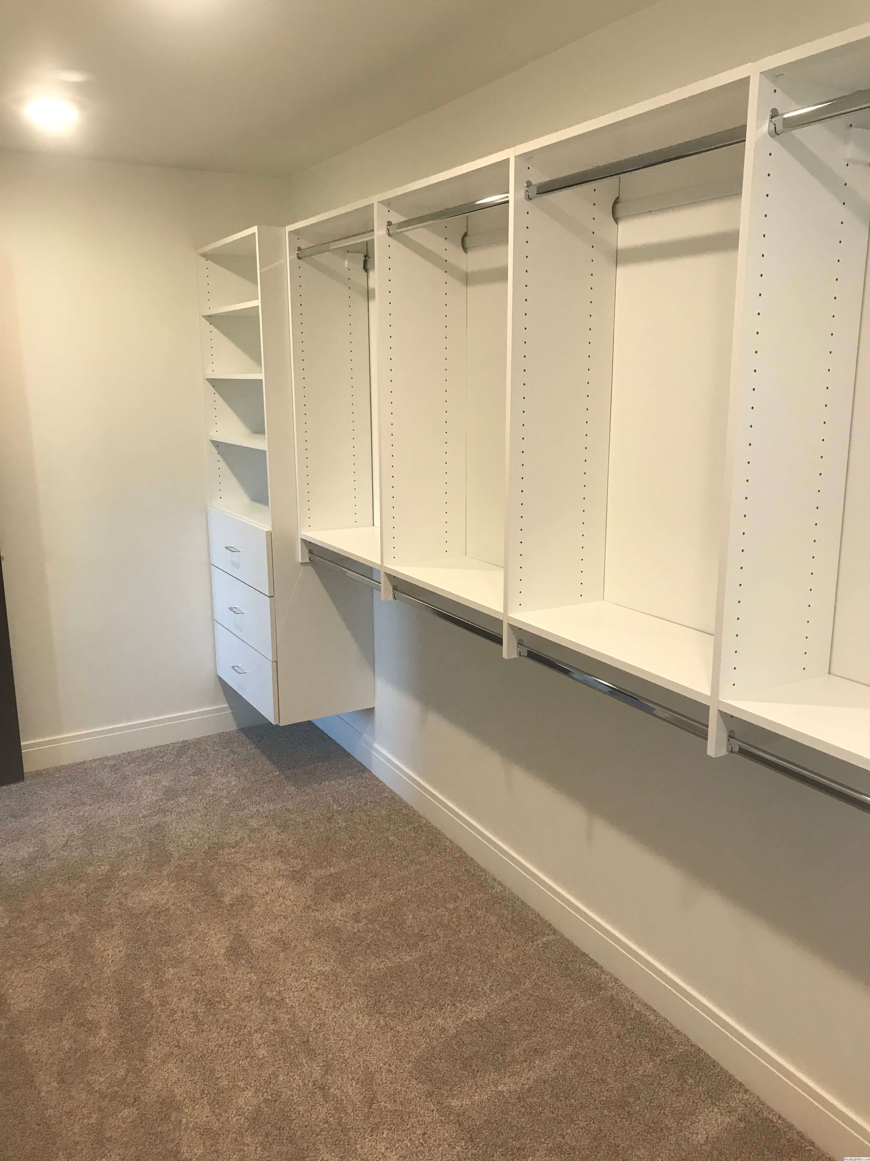 Bright walk-in closet with window light, open shelving, and double hanging space in Green Bay, WI.