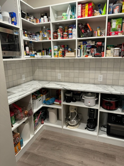 Custom pantry with marble-look countertops, open shelving, and organized small appliance storage in Green Bay, WI.
