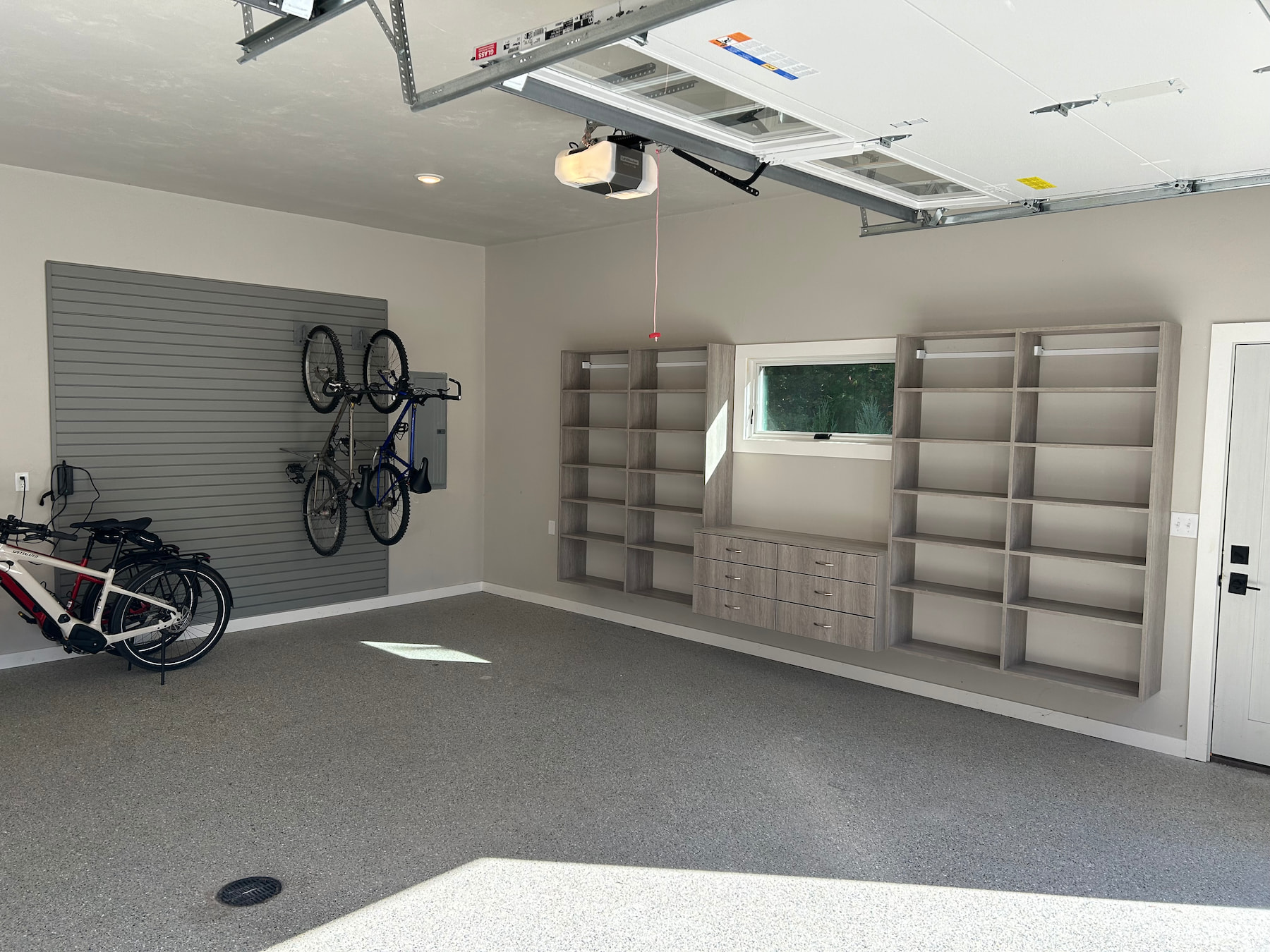 Custom garage storage with wall-mounted cabinets, open shelving, and drawers in Green Bay.