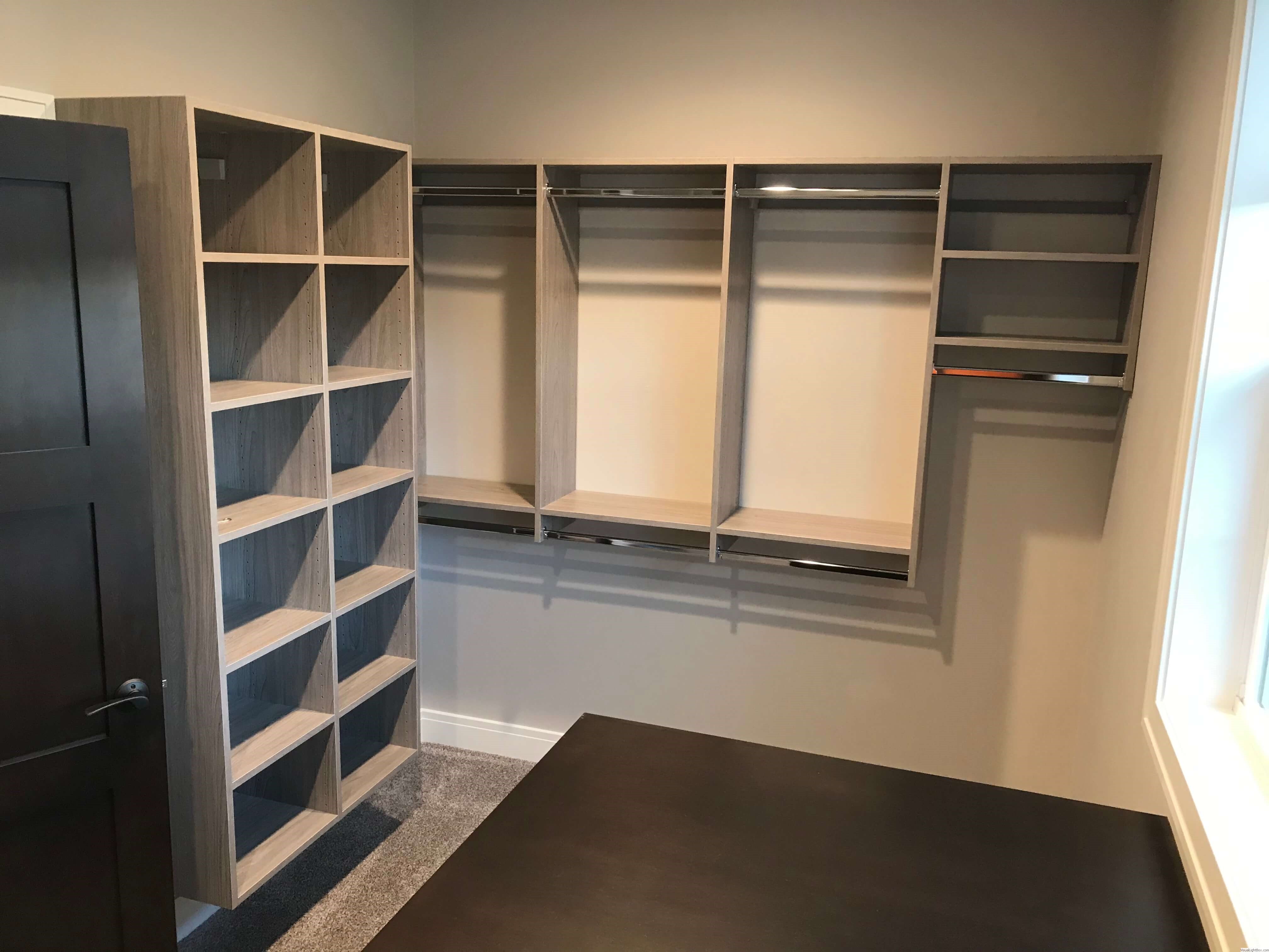 Modern gray wood closet system with open cubby shelving and double hanging rods in Green Bay, WI.