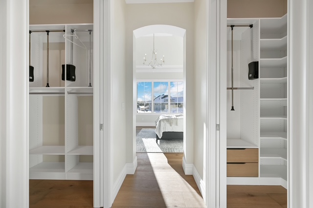 His and hers custom closet with built-in shelving, drawers, and pull-down hanging rods in Green Bay, WI.