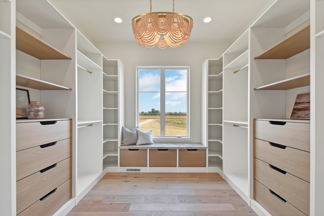 His and hers custom closet with built-in shelving, drawers, and pull-down hanging rods in Green Bay, WI.