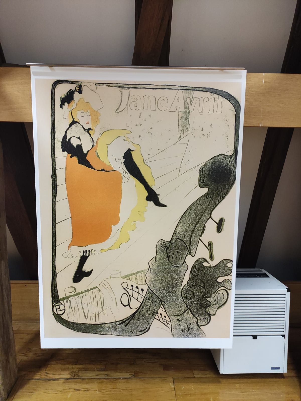 A framed Toulouse-Lautrec colour lithograph on display — the dancer Jane Avril in a black-stockinged high kick over orange and yellow skirts, the scroll of a double bass in the foreground