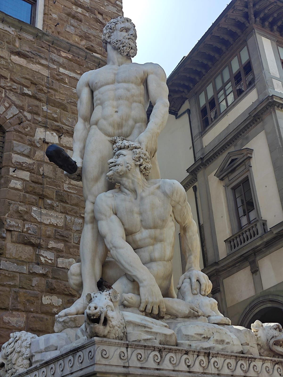 Bandinelli's Hercules and Cacus, two huge white marble figures in front of the rusticated wall of Palazzo Vecchio