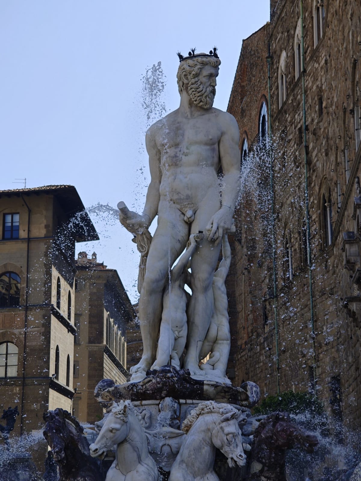 The Neptune fountain from another angle, spray in the air and Palazzo Vecchio's stone wall behind