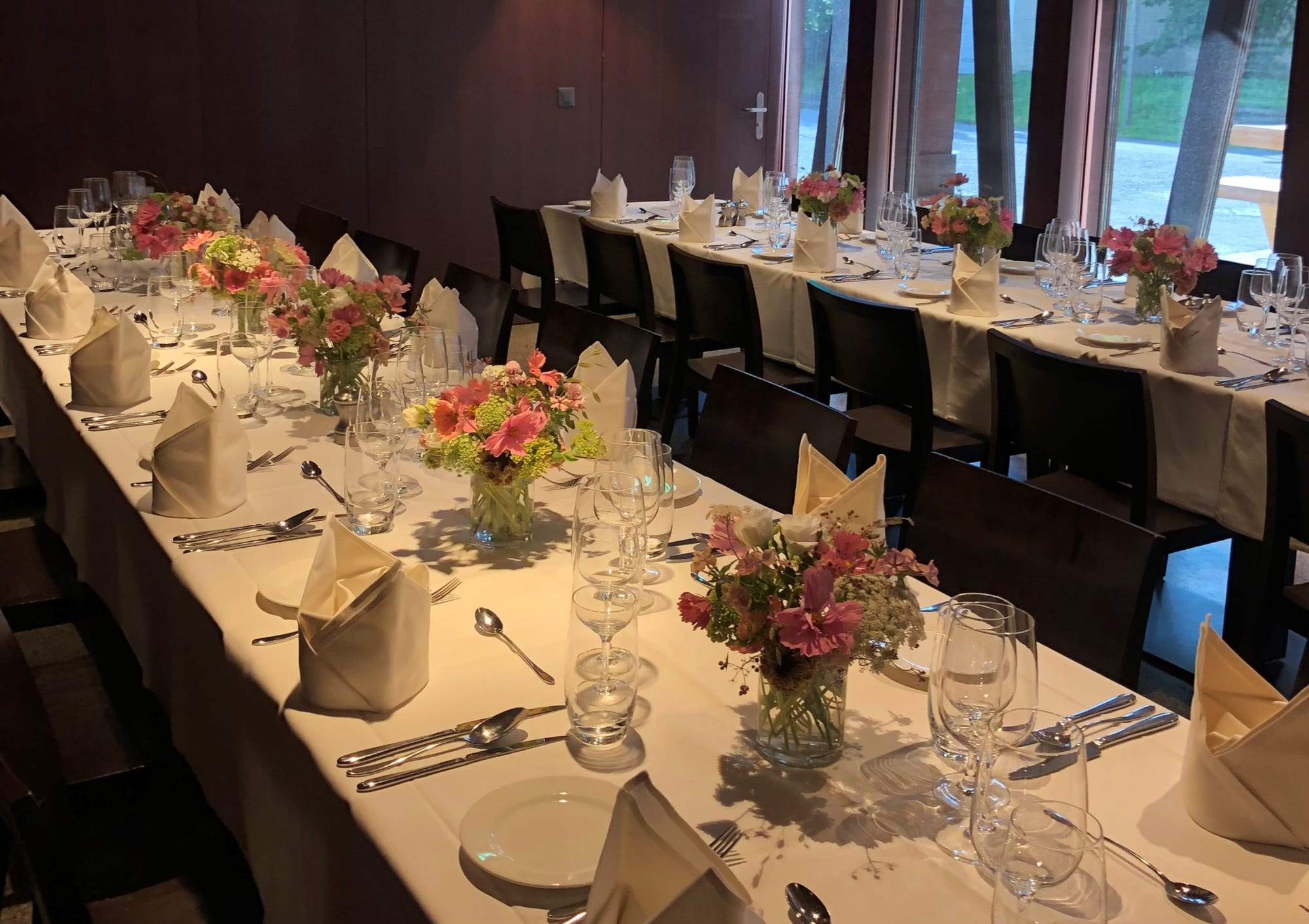 zwei schön gedeckte und geschmückte Tischreihen in der Gaststube