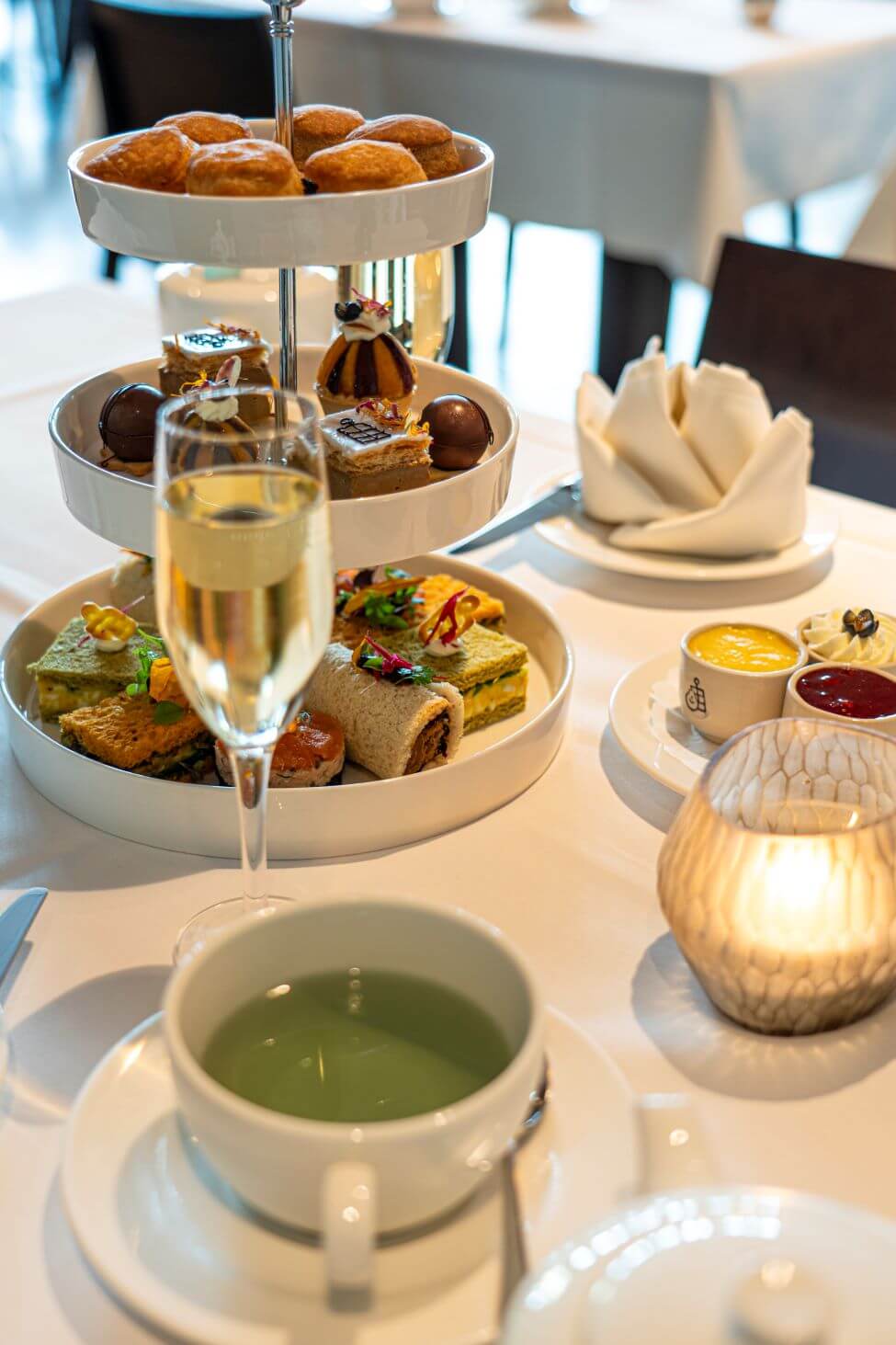 Gefüllte Etagère, Sektglas und Teetasse