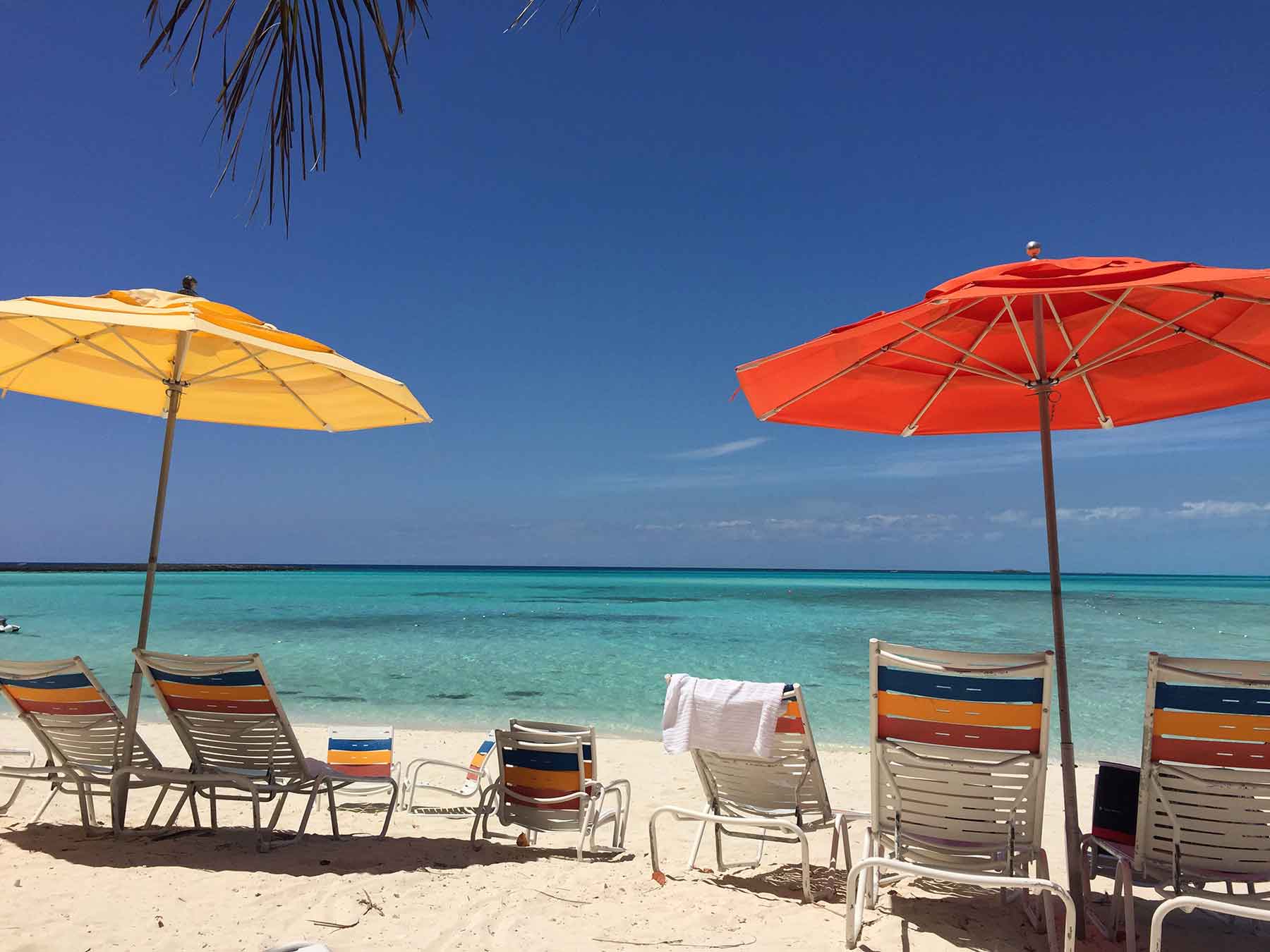 Colorful group of umbrellas nestled on the soft tropical sands of Castaway Cay