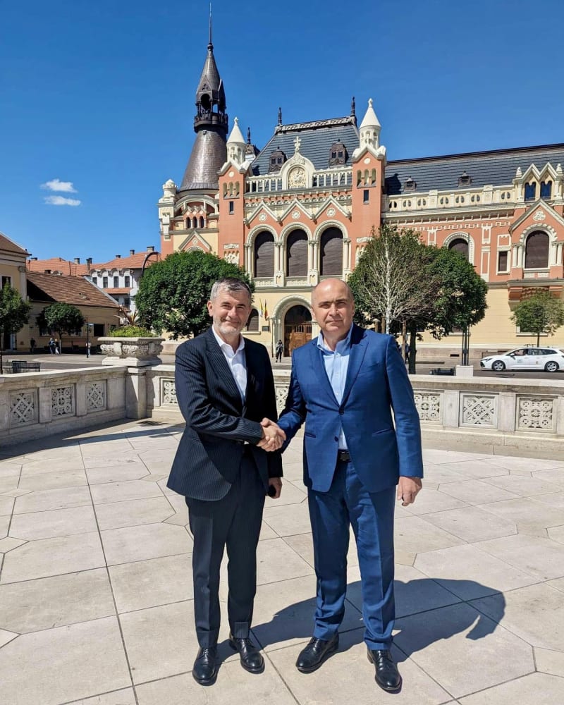 Valeriu Iftime dând mâna cu un oficial, în fața unei clădiri istorice