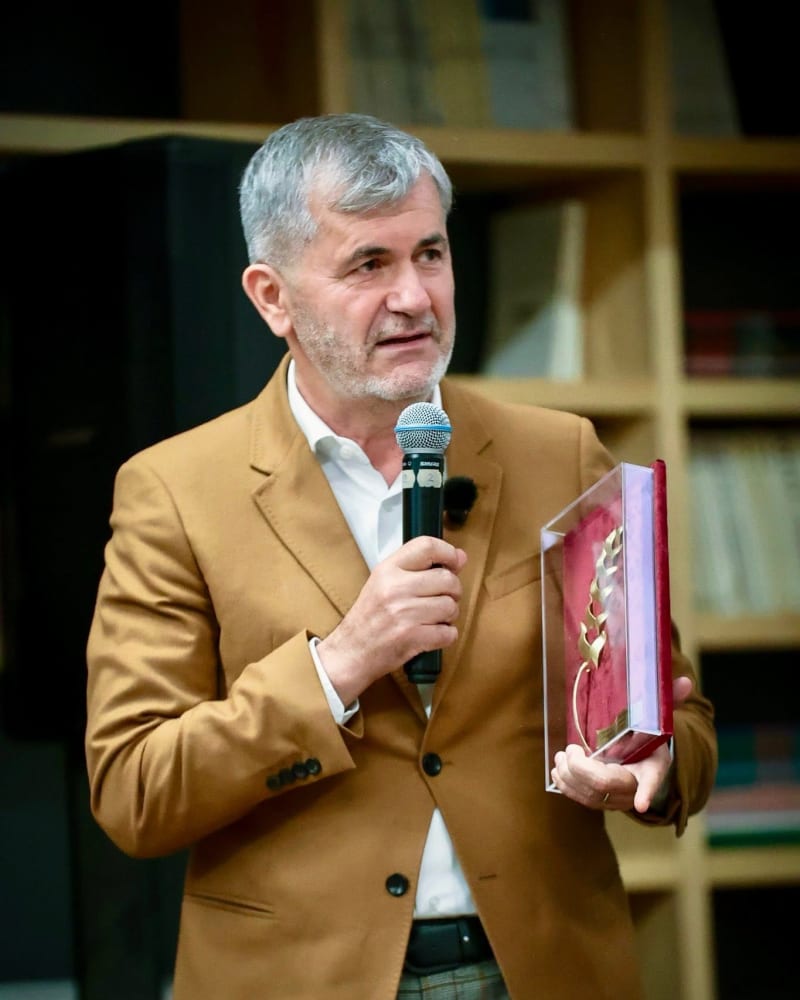 Valeriu Iftime vorbind la microfon, ținând o distincție